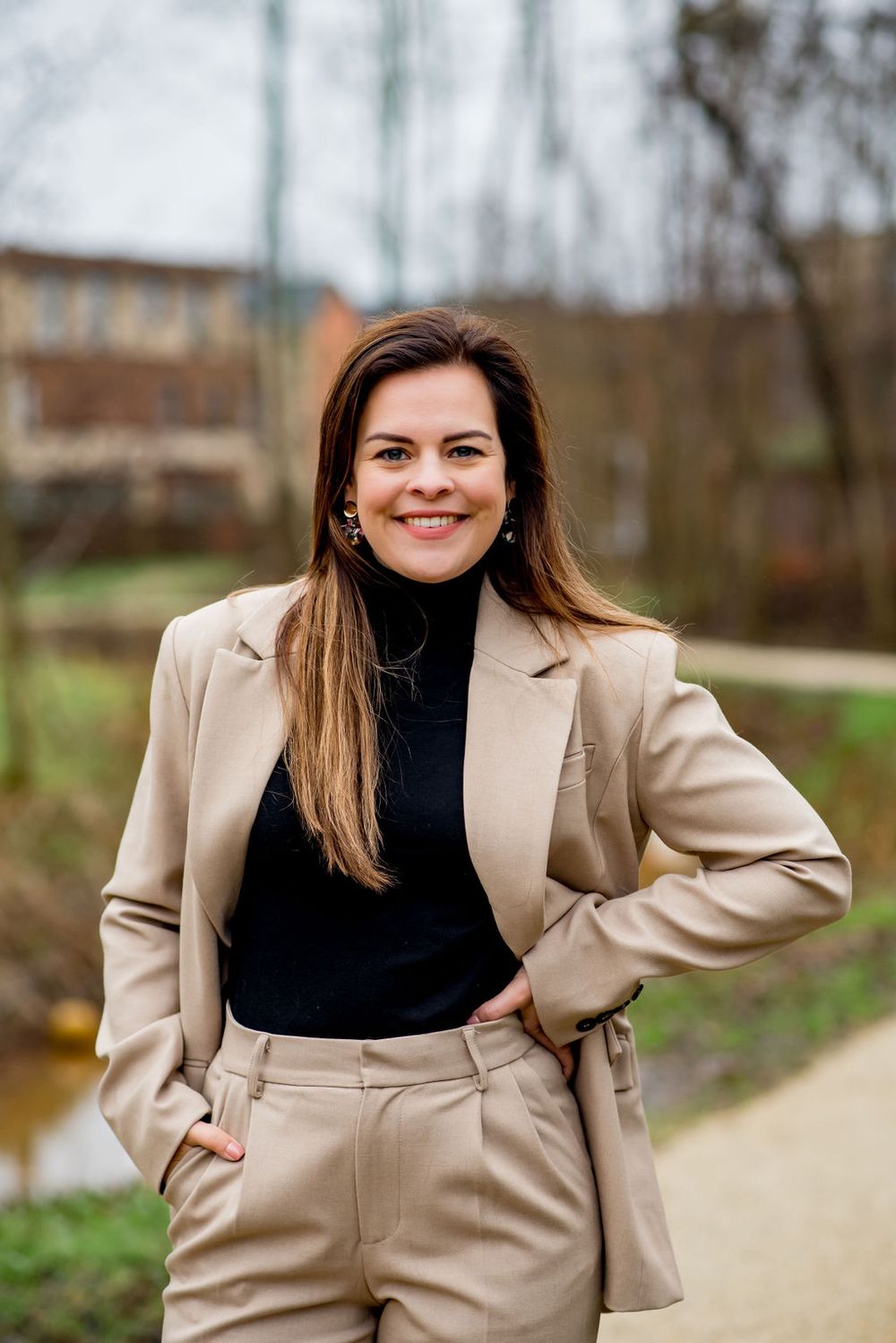 Anne van Loo, lachend in een beige pak